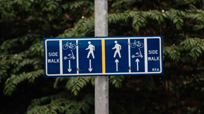 a blue street sign with white arrows pointing in different directions